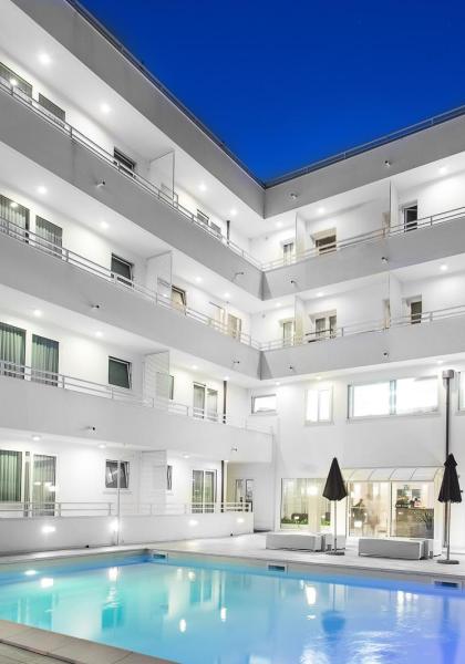 Moderno hotel con piscina illuminata di notte.