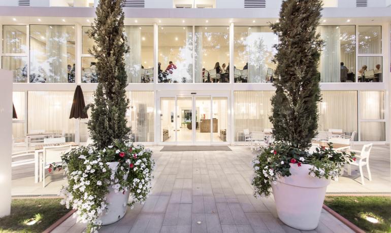 Modern entrance with large windows and decorative plants.
