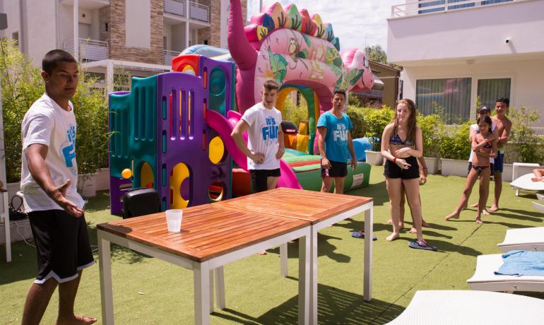 Gioco all'aperto con pallina, tavolo e gonfiabile colorato.