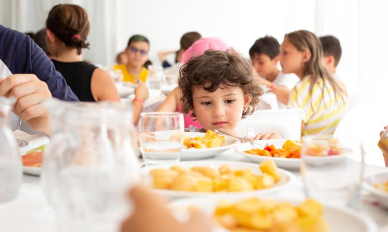 Enfants assis à table, prêts à manger.