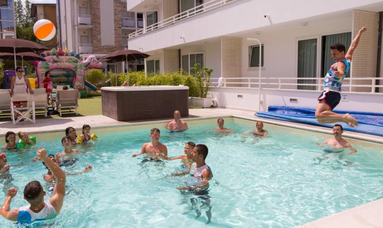 Des gens s'amusent dans une piscine avec un ballon.