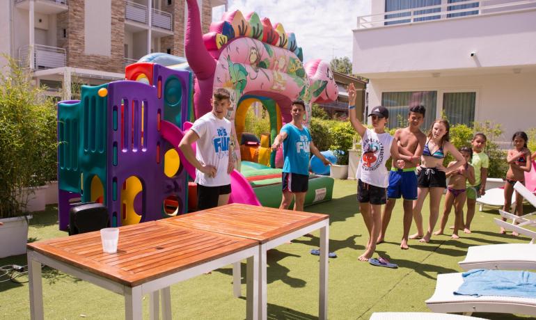 Activité en plein air avec jeux gonflables et enfants à la piscine.
