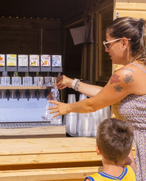 Femme remplit une bouteille d'eau à un distributeur.