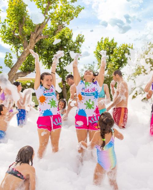 Des gens s'amusent à une fête de mousse en plein air.
