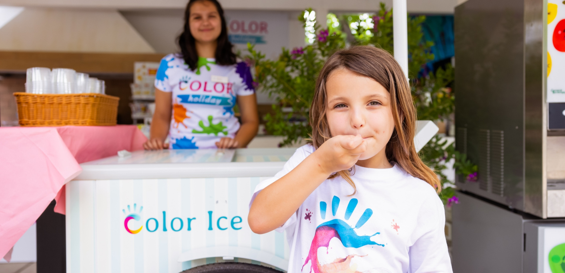 Happy girl enjoys colorful ice cream, smiles and summer joy.