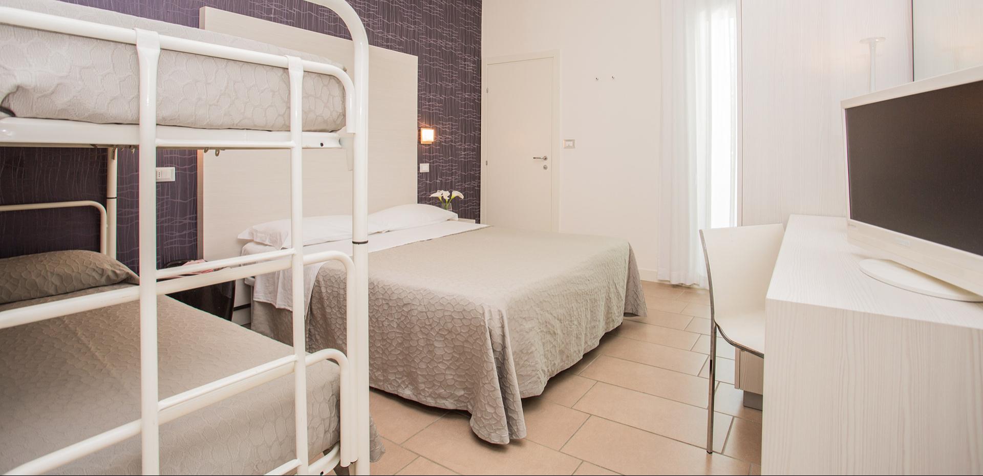 Famiglia felice in una stanza, bambina con peluche su letto a castello.
