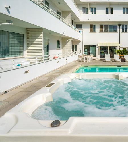 Pool und Whirlpool in einem Hotel, entspannte und sonnige Atmosphäre.
