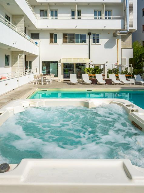 Pool und Whirlpool in einem Hotel, entspannte und sonnige Atmosphäre.