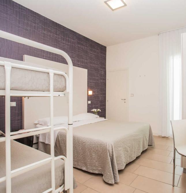 Cozy room with a double bed and bunk beds, relaxing ambiance.