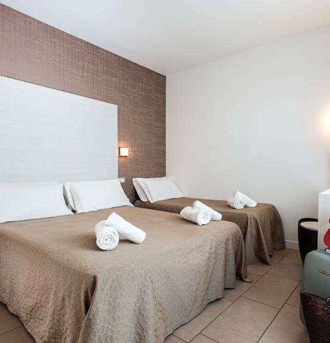 Bright room with cozy beds and a suitcase ready for adventure.