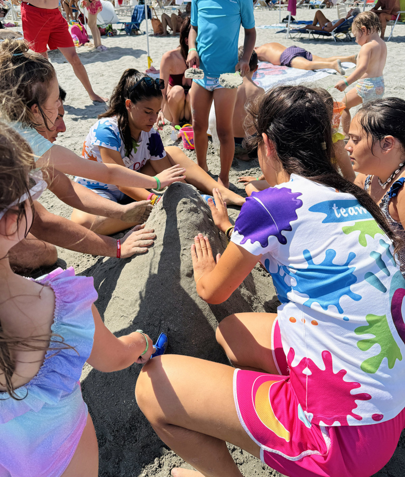 Happy children build a sand sculpture on the sunny beach.